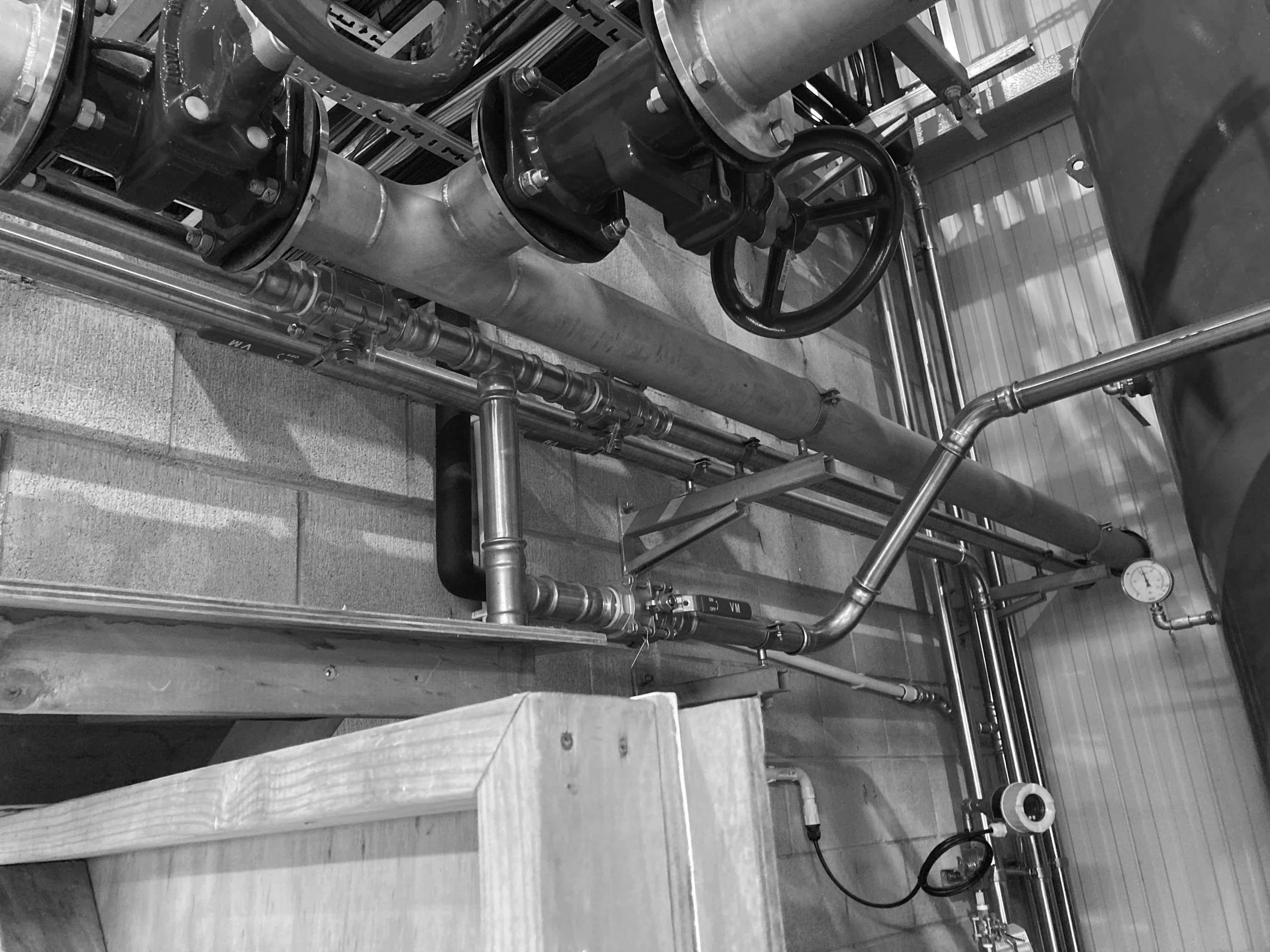 Plumbing risers running alongside mechanical services
