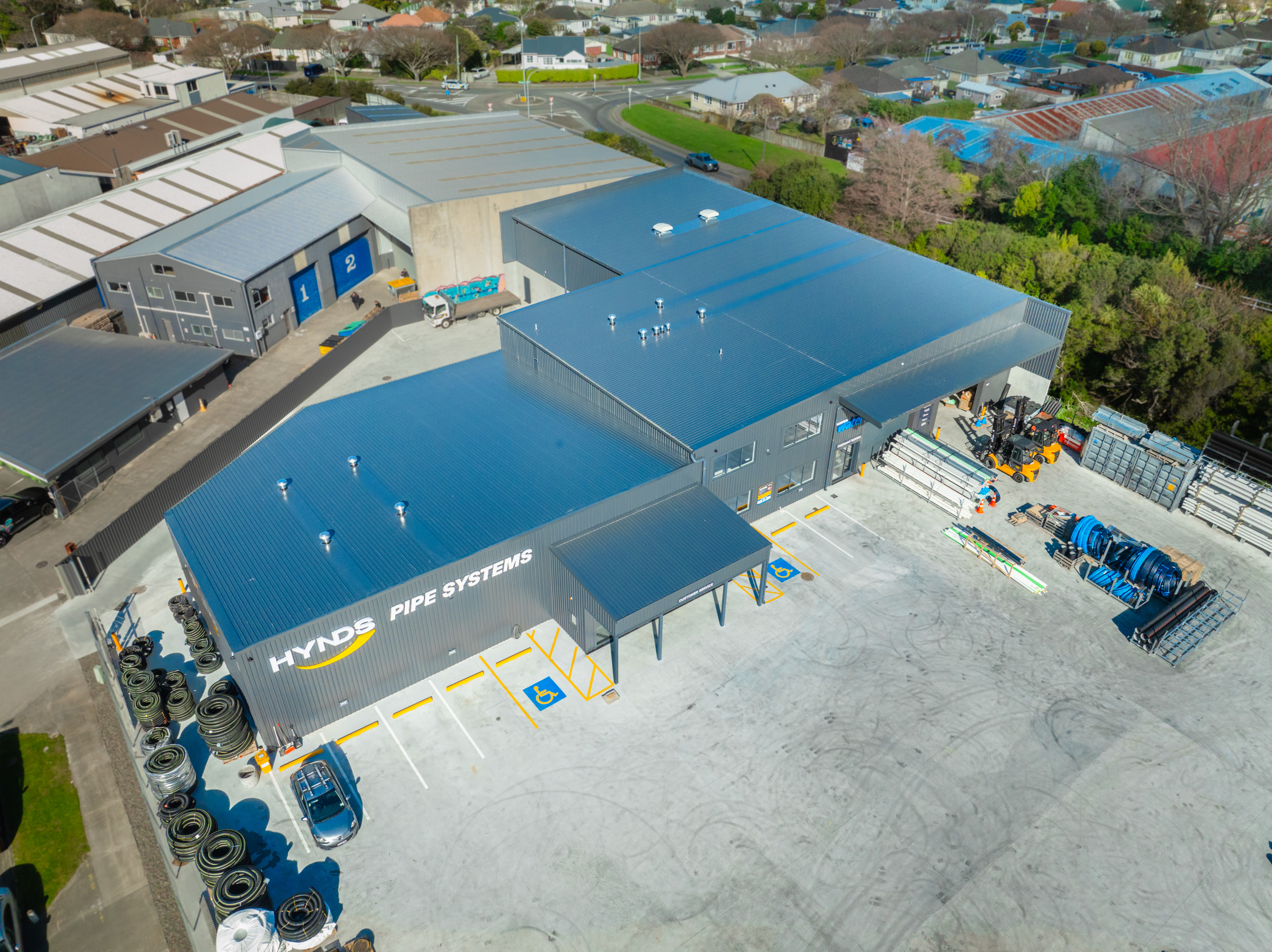 Aerial close of the completed roofline over a stocked yard