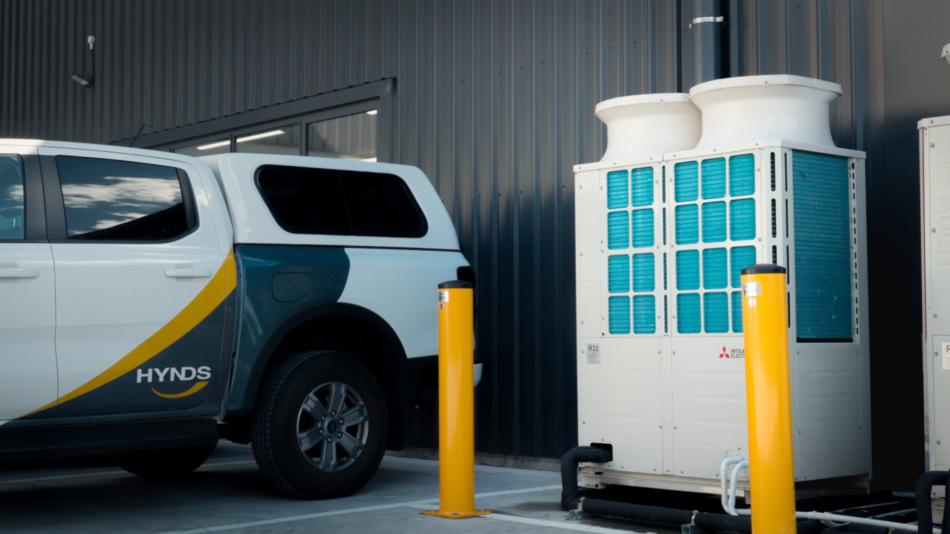 Hynds branded ute parked beside a City Multi outdoor unit