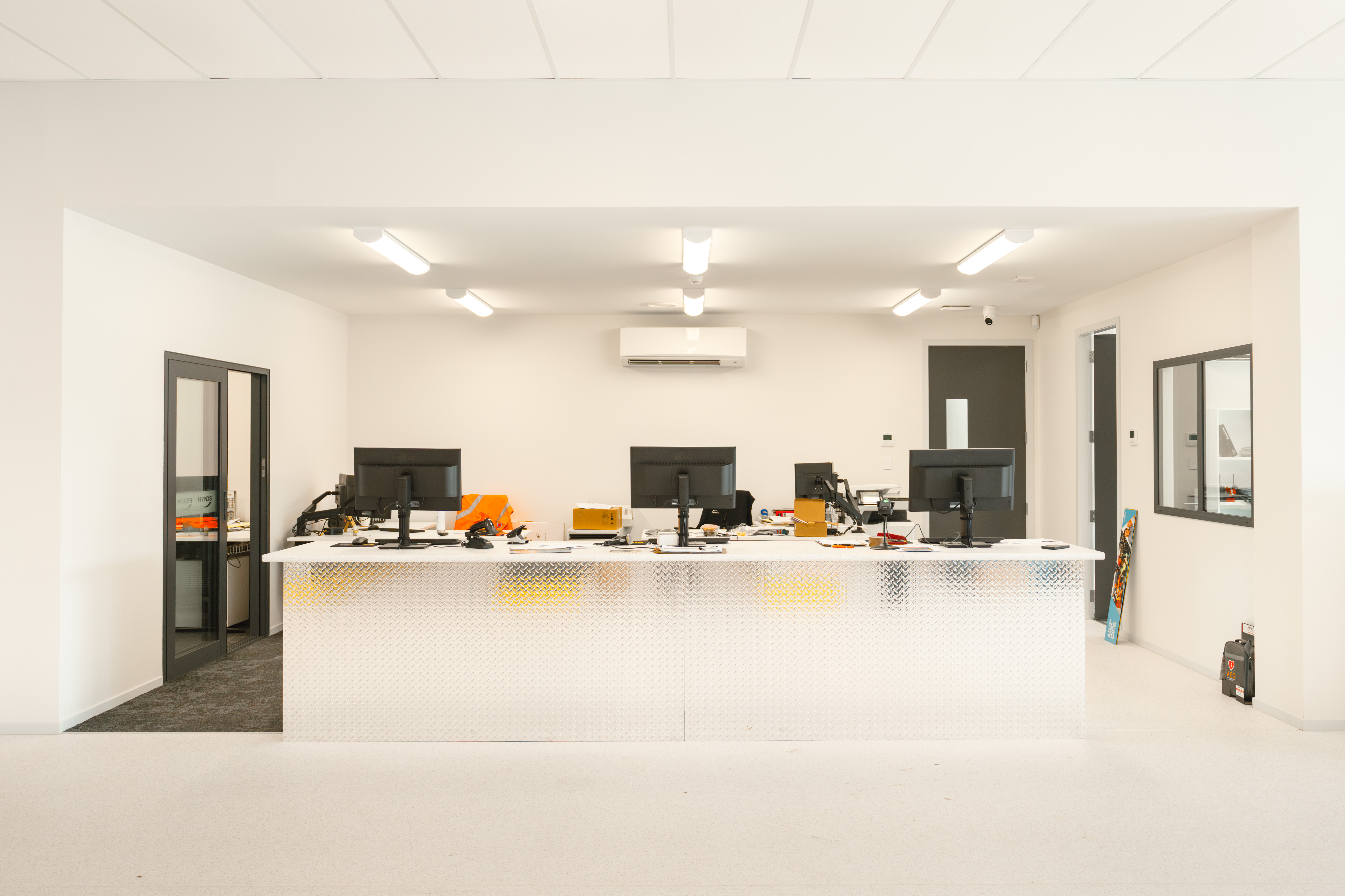Customer service counter with diamond-plate cladding under even lighting